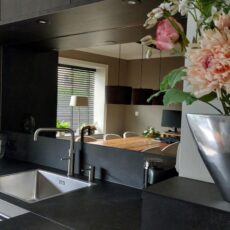 Espejo de bronce en la pared de la cocina, detrás del fregadero